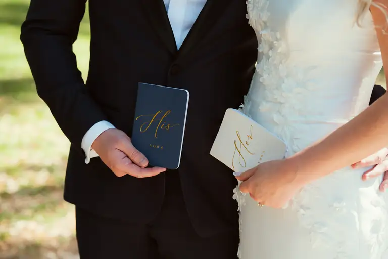 Bride and groom holding their vow books