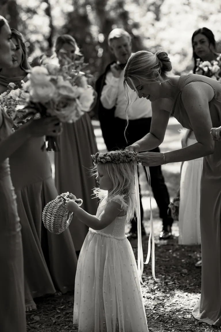 The flower girl handing the bride her bouquet, black and white