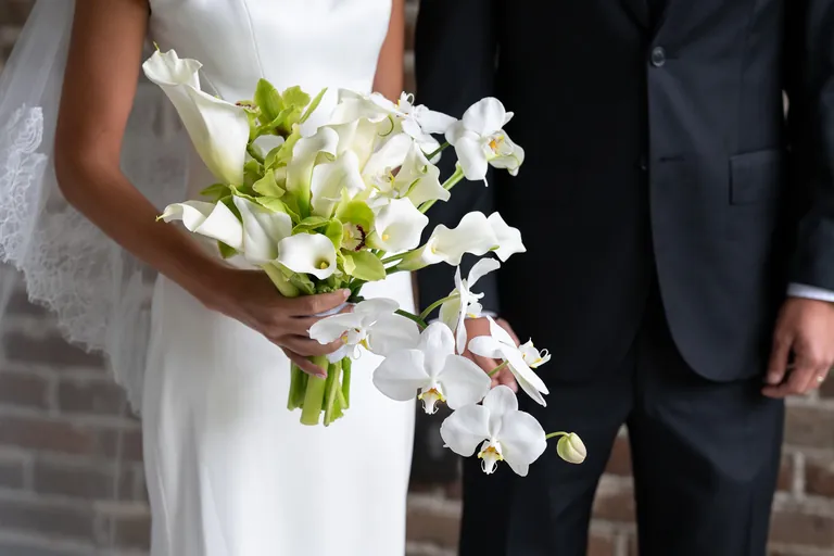 The bride's white calla lily bouquet as she stands beside her groom
