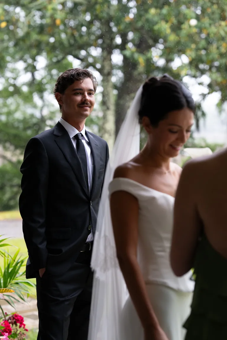 A bride and groom laughing together beneath the oaks