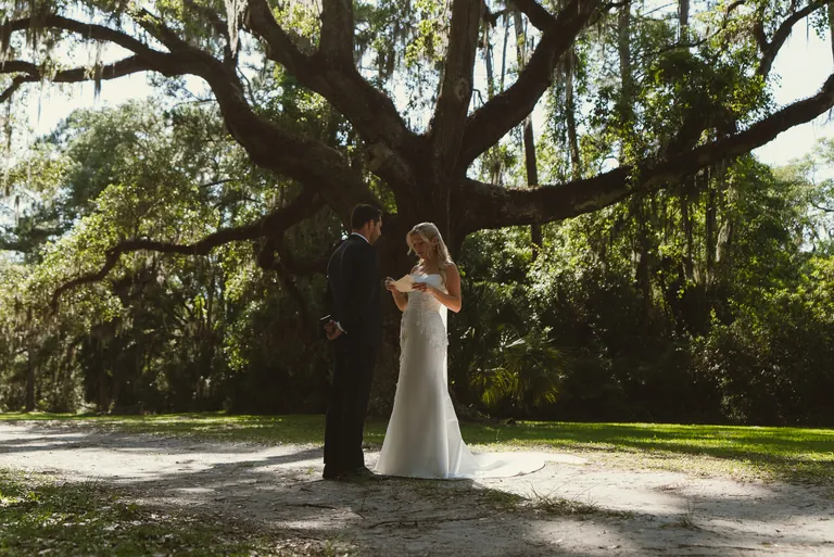 A bride standing beneath a sprawling live oak