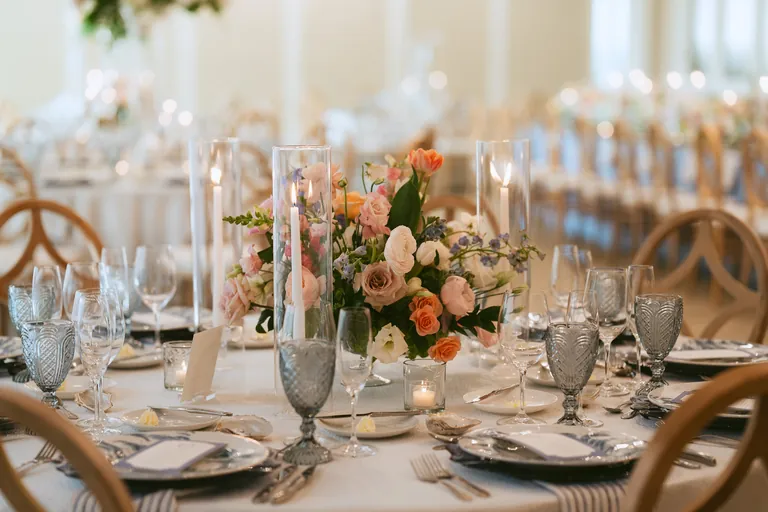 Candlelit reception table with peach roses and crystal glassware